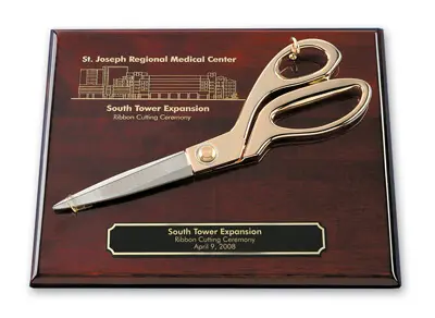 Ceremonial gold scissors mounted on a grand opening plaque